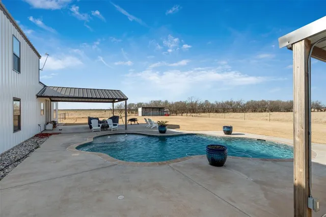 a view of a swimming pool with an outdoor seating and a yard