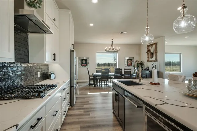 a kitchen with sink stove and cabinets