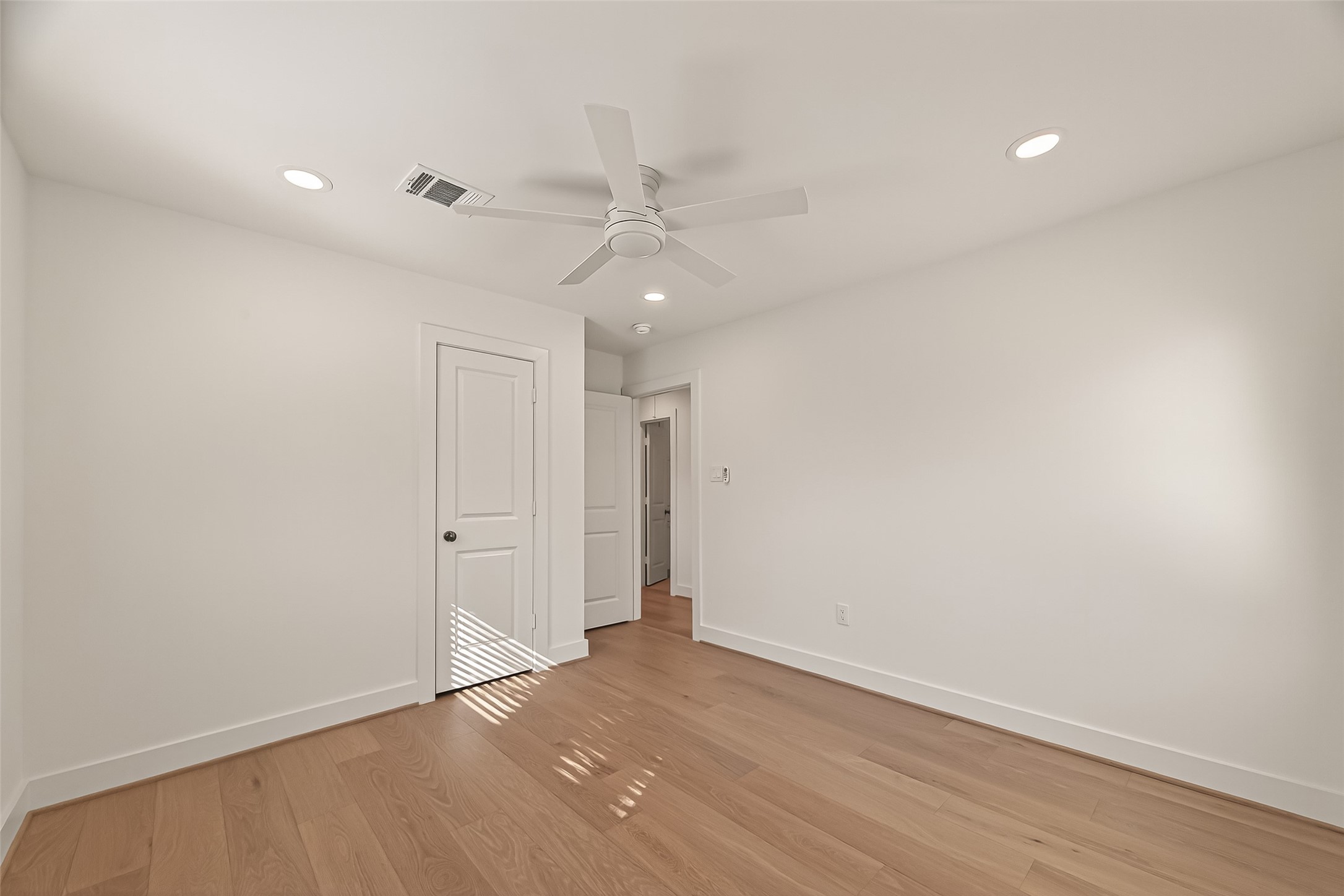 9242 Autauga Street Houston, TX 77080 - Photo 27 of 49 an empty room with wooden floor and fan
