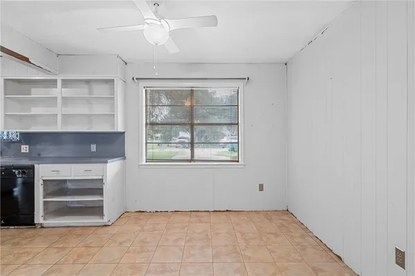 a view of an empty room with a fireplace and a window