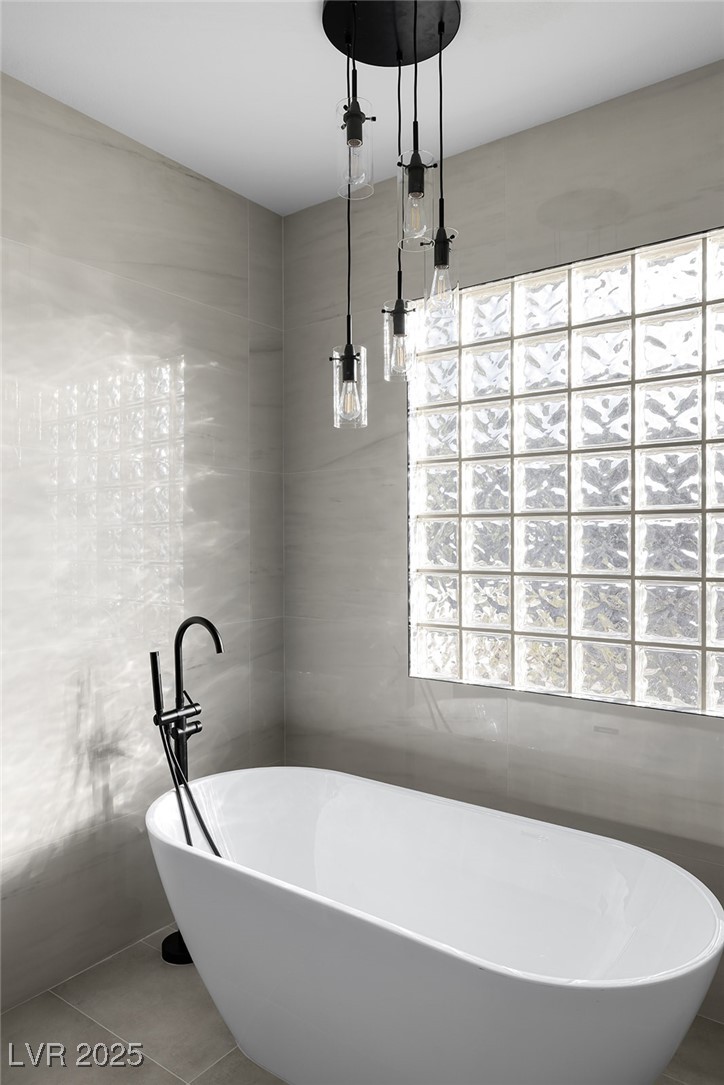 7 Summit Walk Trail Henderson, NV 89052 - Photo 28 of 61 Full bathroom featuring tile walls, a soaking tub, and tile patterned flooring