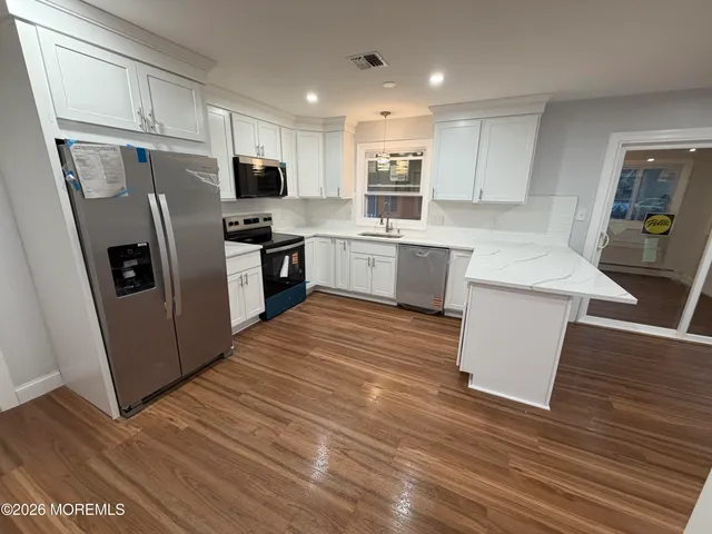a kitchen with white cabinets and stainless steel appliances