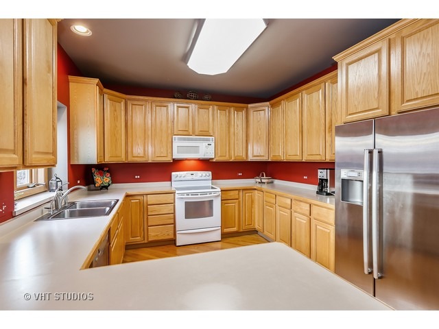 10808 West Riviera Drive Spring Grove, IL 60081 - Photo 6 of 16 a kitchen with stainless steel appliances granite countertop a sink a stove and refrigerator