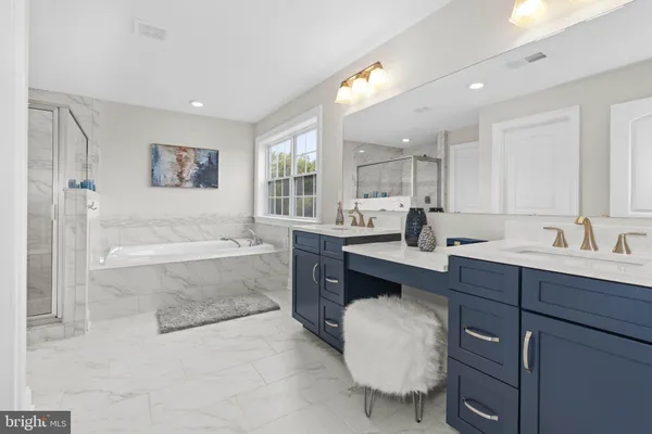 a spacious bathroom with a tub double sink and mirror