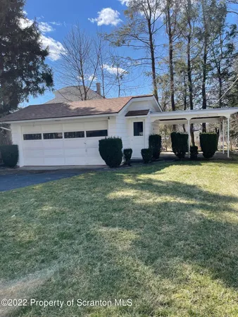 a view of a white house with many windows and a yard