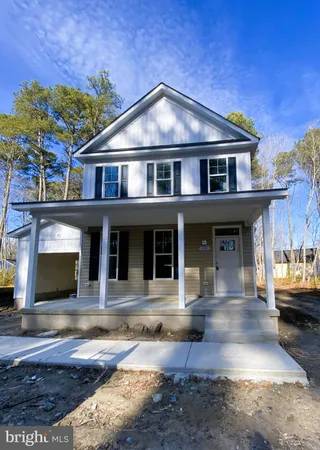 a front view of a house with yard and furniture