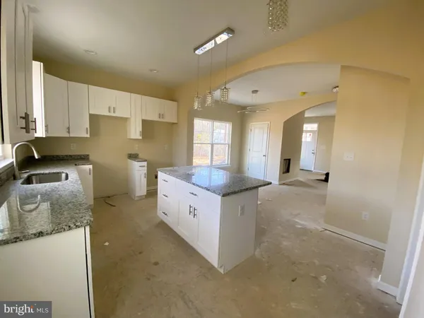 a kitchen with granite countertop a sink and a stove top oven