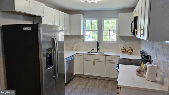 a kitchen with stainless steel appliances a refrigerator sink and cabinets