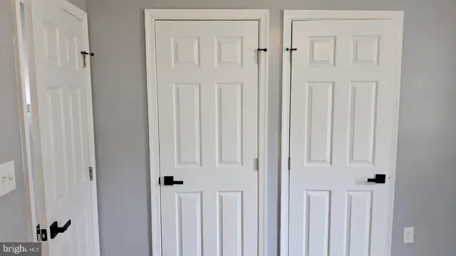 a view of a hallway with wooden floor and closet area