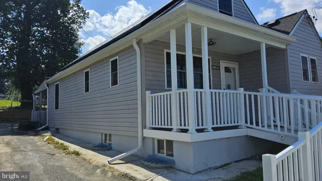 a view of a house with a small yard and wooden fence