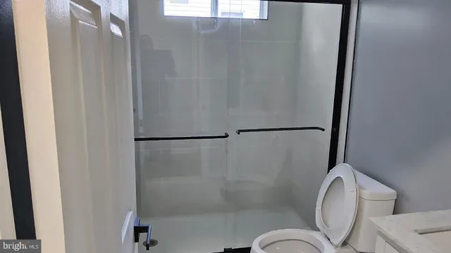 a bathroom with a granite countertop shower and a sink