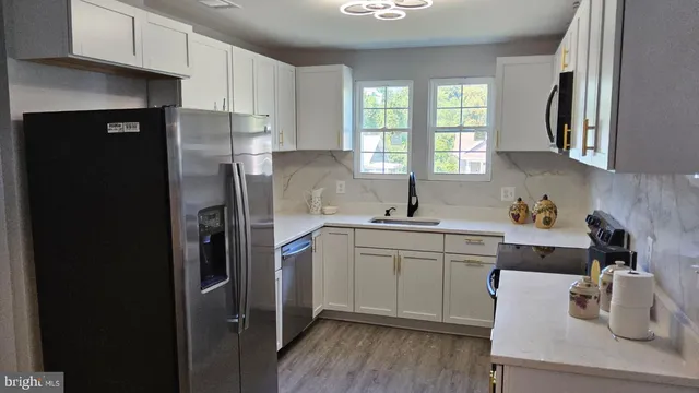 a kitchen with stainless steel appliances a sink cabinets and a window