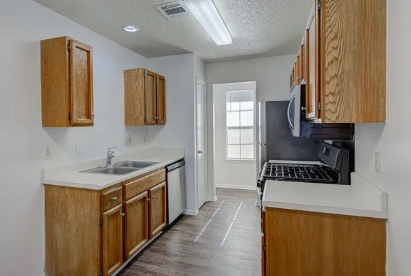 a kitchen with stainless steel appliances granite countertop a stove a sink and a refrigerator