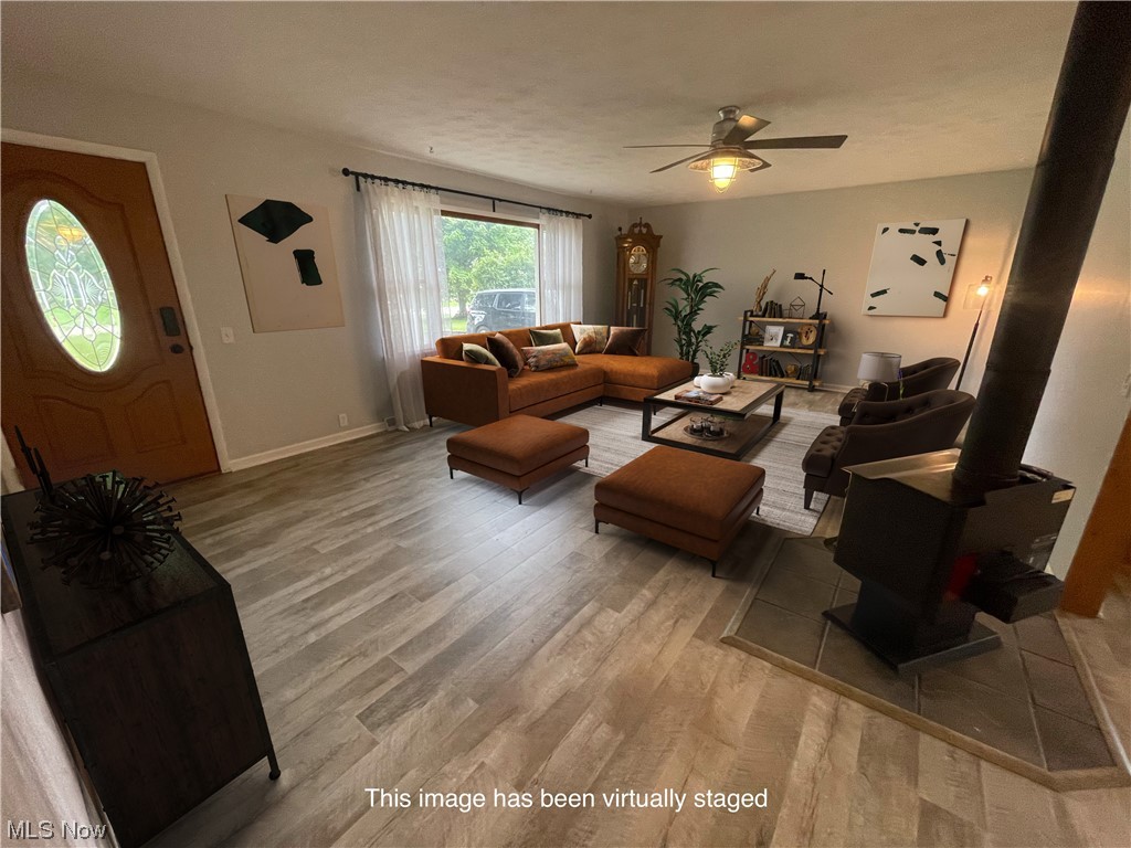 2345 Antioch Road Perry, OH 44081 - Photo 4 of 17 Living room with a wood stove, ceiling fan, and light hardwood / wood-style floors