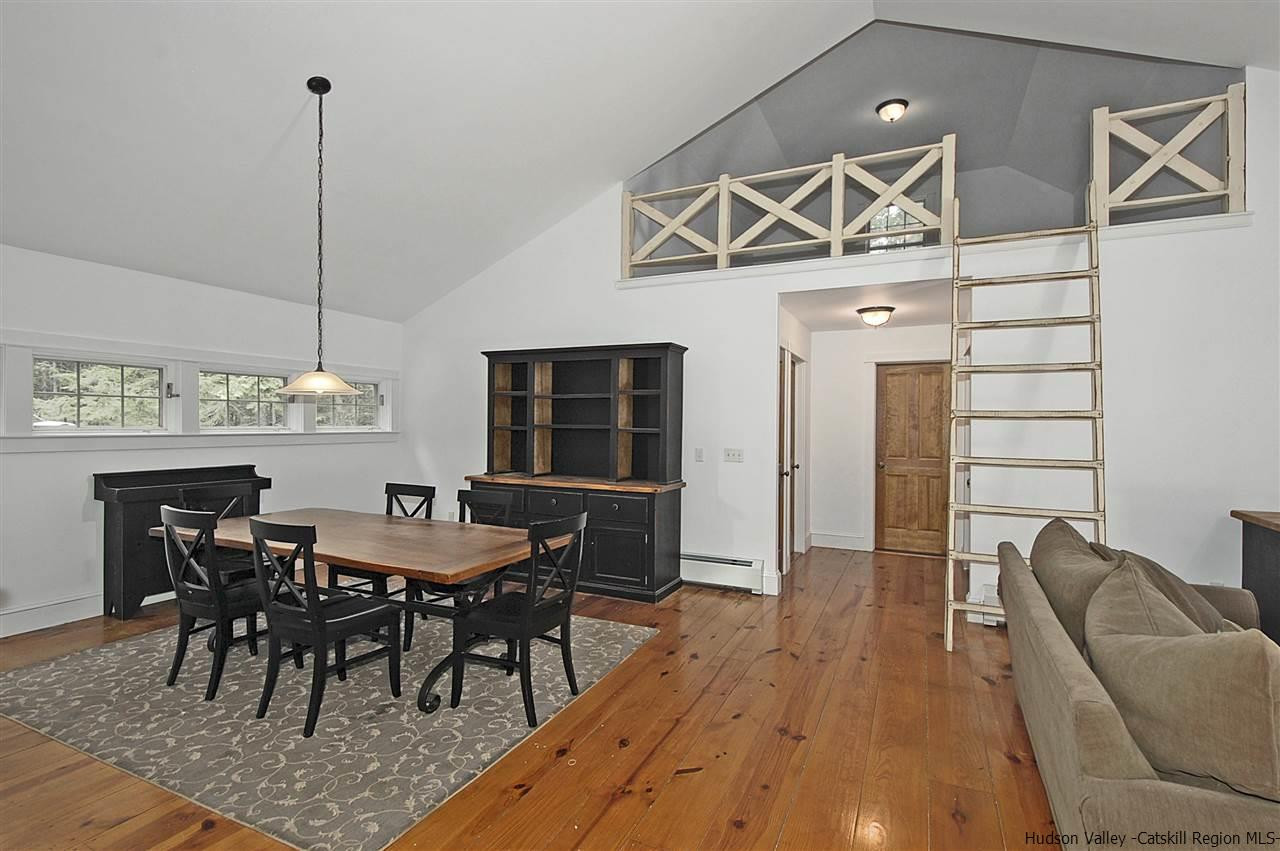 522 Buck Road Stone Ridge, NY 12484 - Photo 13 of 30 a view of a dining room and livingroom with furniture wooden floor and a chandelier
