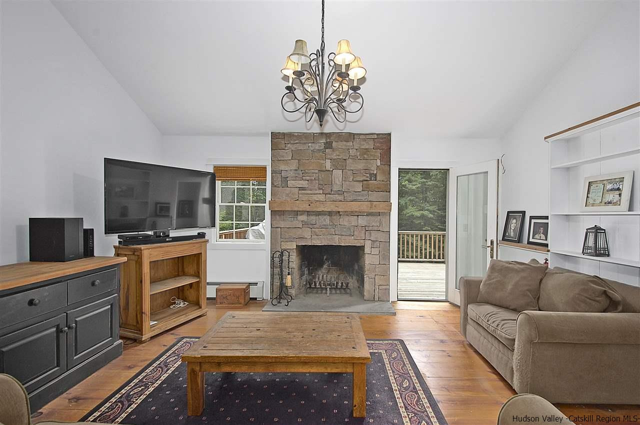 522 Buck Road Stone Ridge, NY 12484 - Photo 14 of 30 a living room with furniture a flat screen tv and a fireplace