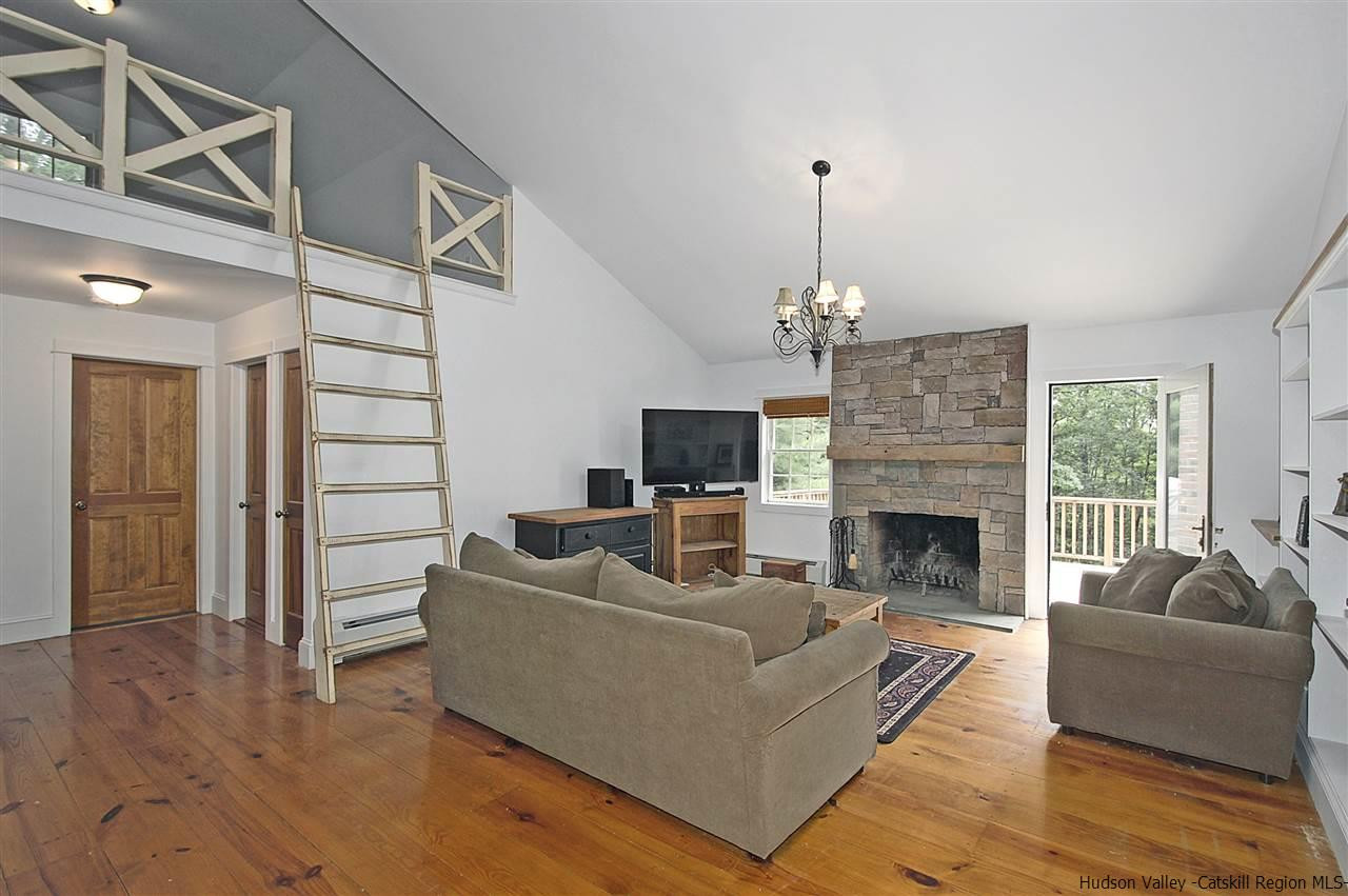 522 Buck Road Stone Ridge, NY 12484 - Photo 6 of 30 a living room with furniture a fireplace and a chandelier