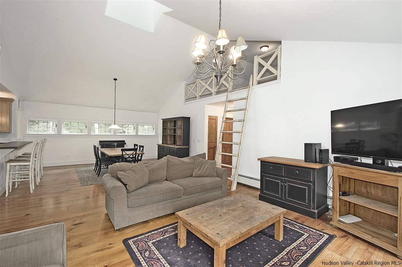 522 Buck Road Stone Ridge, NY 12484 - Photo 7 of 30 a living room with furniture a flat screen tv and kitchen view