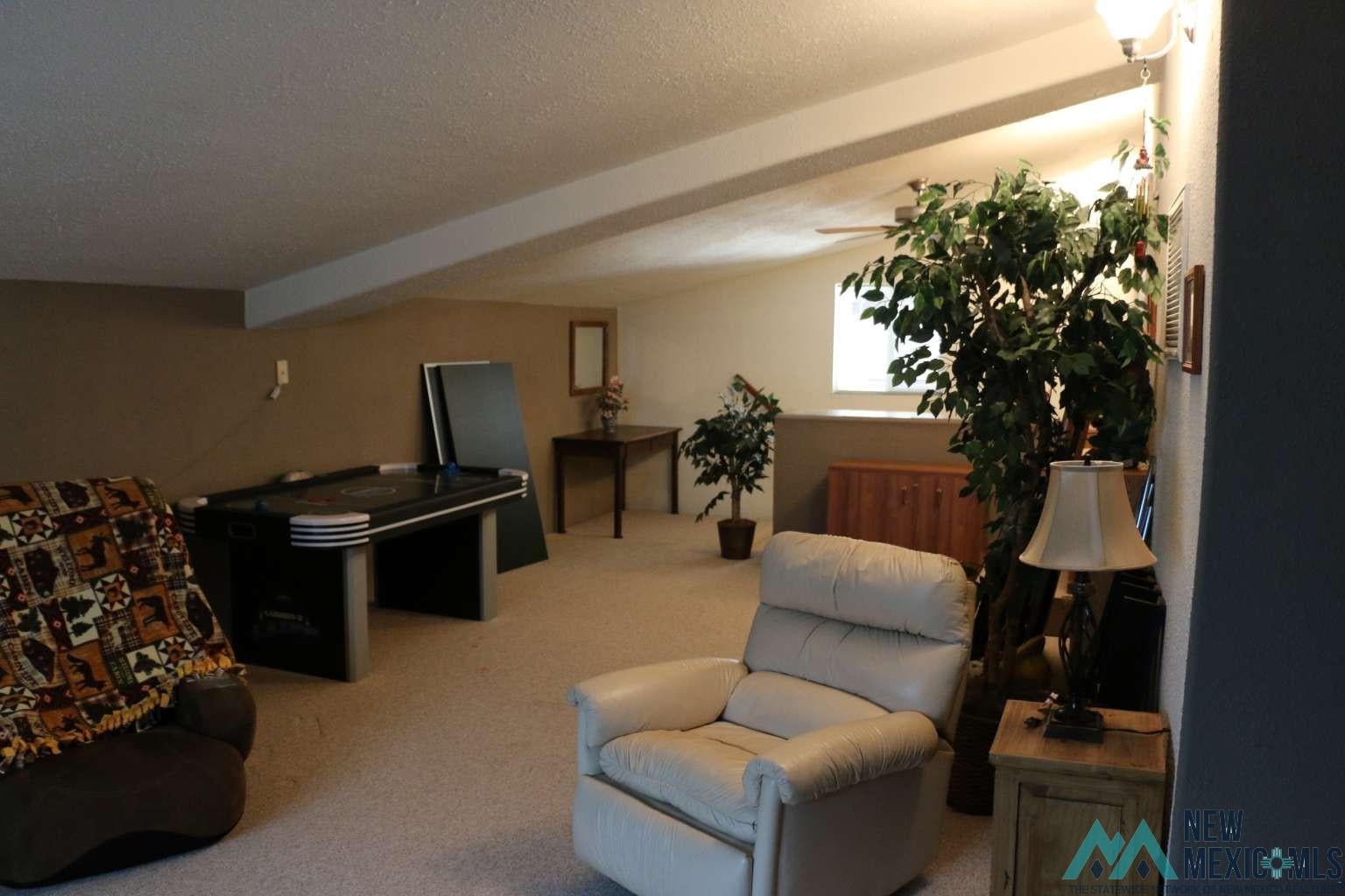 32 Dan Gatlin Road Pie Town, NM 87827 - Photo 38 of 43 Living area with carpet flooring and a textured ceiling