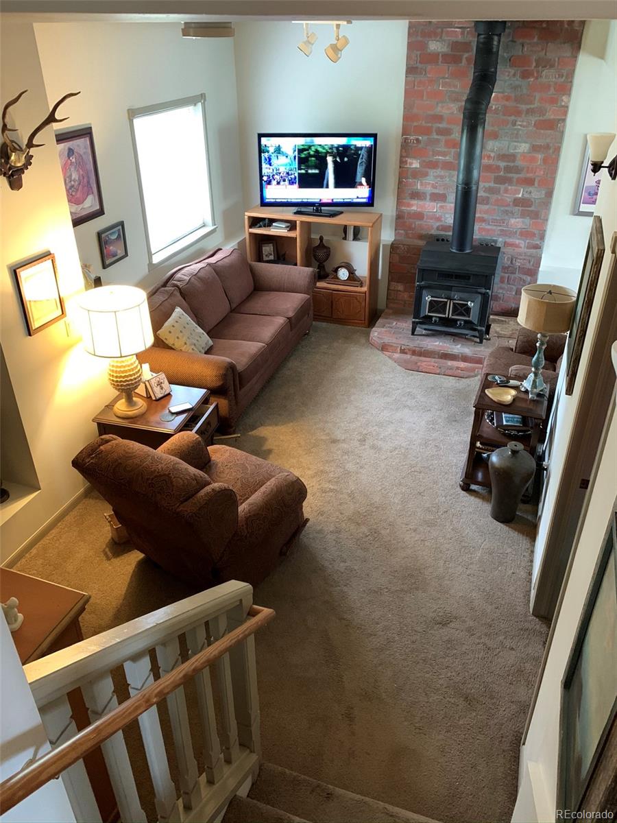 161 Saddlestring Road Bailey, CO 80421 - Photo 10 of 32 a living room with furniture and a flat screen tv
