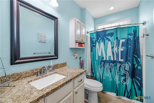 a bathroom with a granite countertop sink toilet and shower