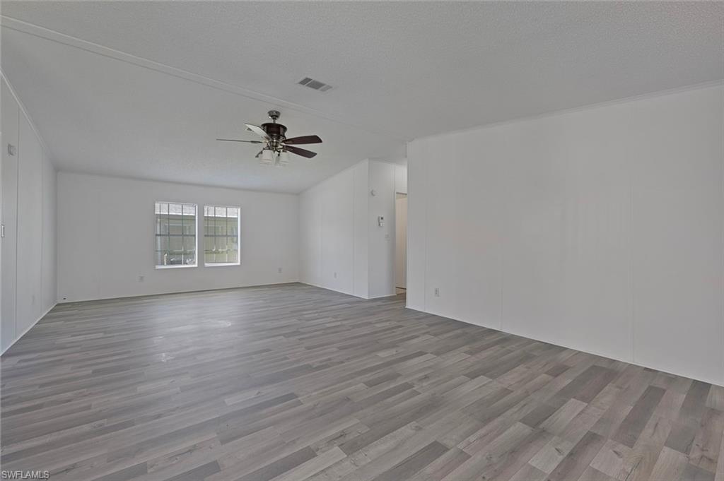 276 Grosbeak Lane, Unit 276 Naples, FL 34114 - Photo 2 of 13 wooden floor in an empty room with a window
