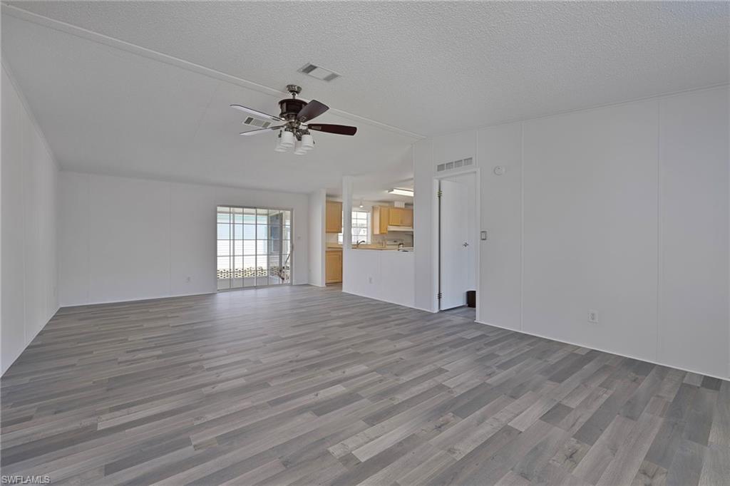 276 Grosbeak Lane, Unit 276 Naples, FL 34114 - Photo 3 of 13 a view of empty room with wooden floor and fan
