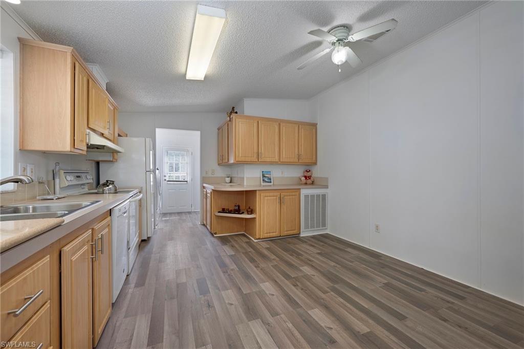 276 Grosbeak Lane, Unit 276 Naples, FL 34114 - Photo 4 of 13 a kitchen with a stove a sink and a refrigerator