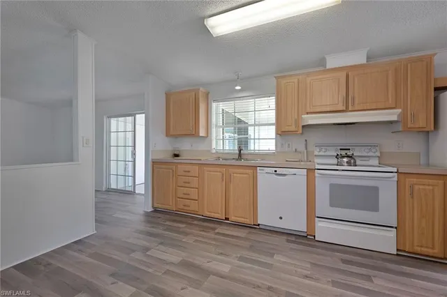 a kitchen with granite countertop white cabinets and white appliances