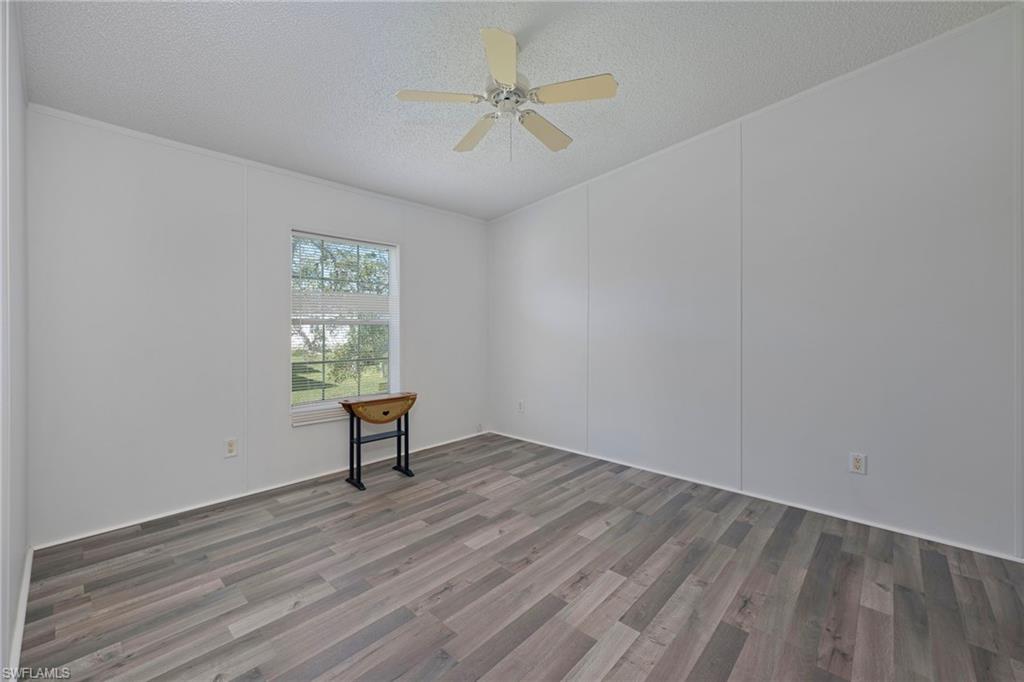 276 Grosbeak Lane, Unit 276 Naples, FL 34114 - Photo 10 of 13 an empty room with a window and a ceiling fan