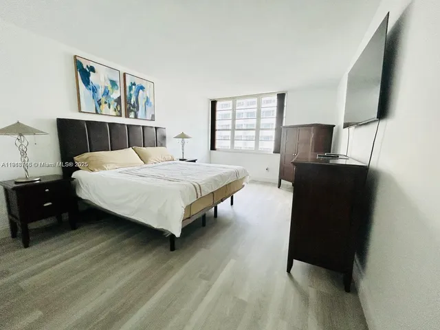 a bedroom with a bed dresser and window