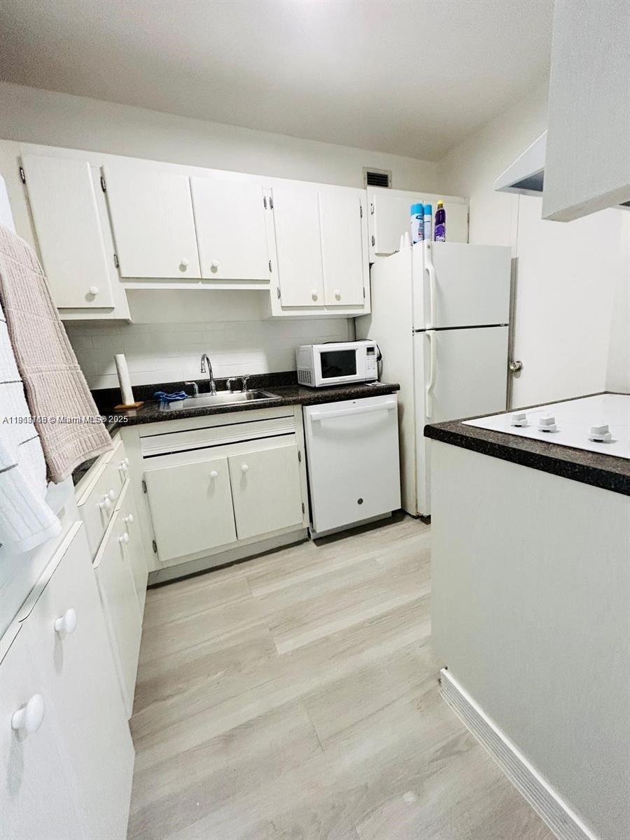 100 Lincoln Road, Unit 535 Miami Beach, FL 33139 - Photo 3 of 12 a kitchen with granite countertop a sink a stove a refrigerator and white cabinets