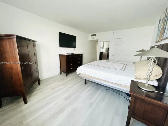 a bedroom with a bed and a television