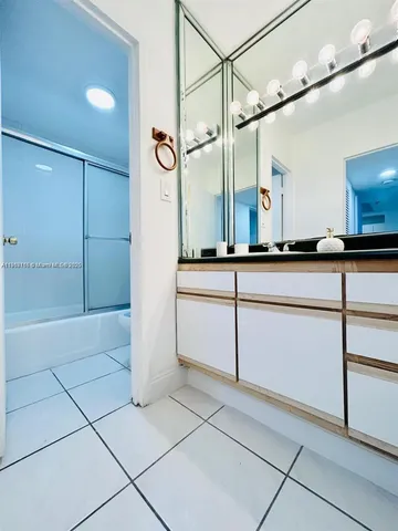 a bathroom with a sink a mirror and a shower