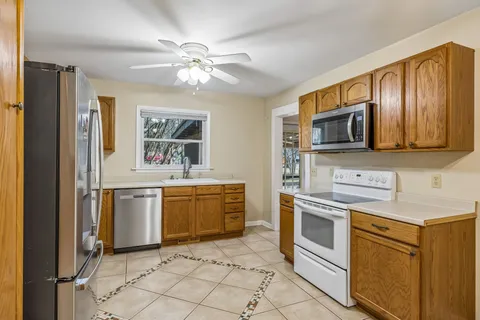 a kitchen with stainless steel appliances granite countertop a stove a sink and a refrigerator