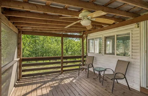 a roof deck with table and chairs and wooden floor
