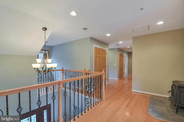 a view of a hallway with a livingroom and chandelier