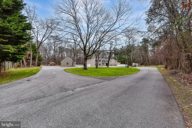 a view of a house with a big yard and large trees
