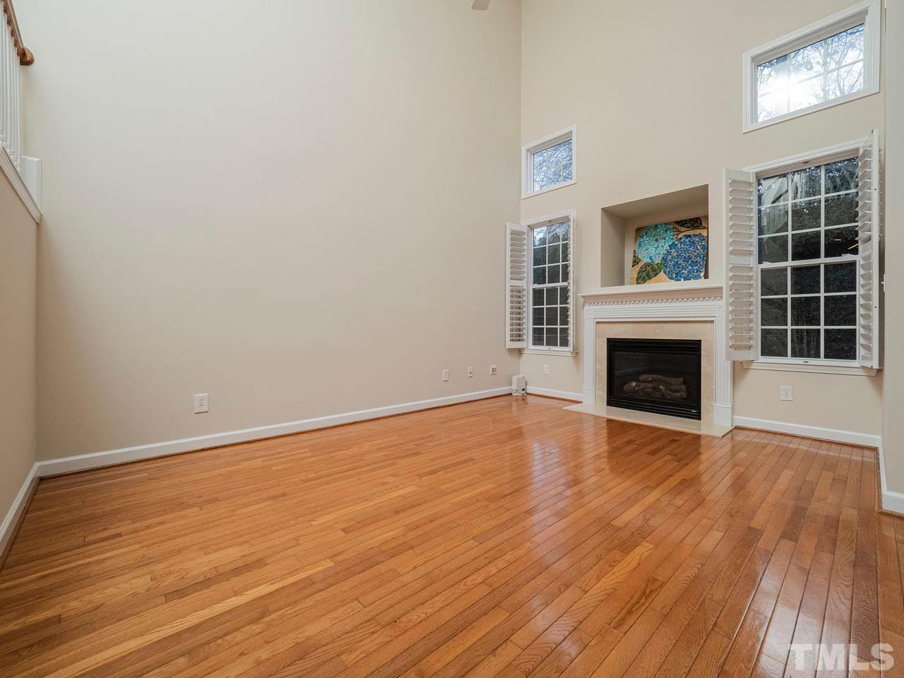 6025 Four Townes Lane Raleigh, NC 27616 - Photo 12 of 24 a view of an empty room with wooden floor fireplace and a window