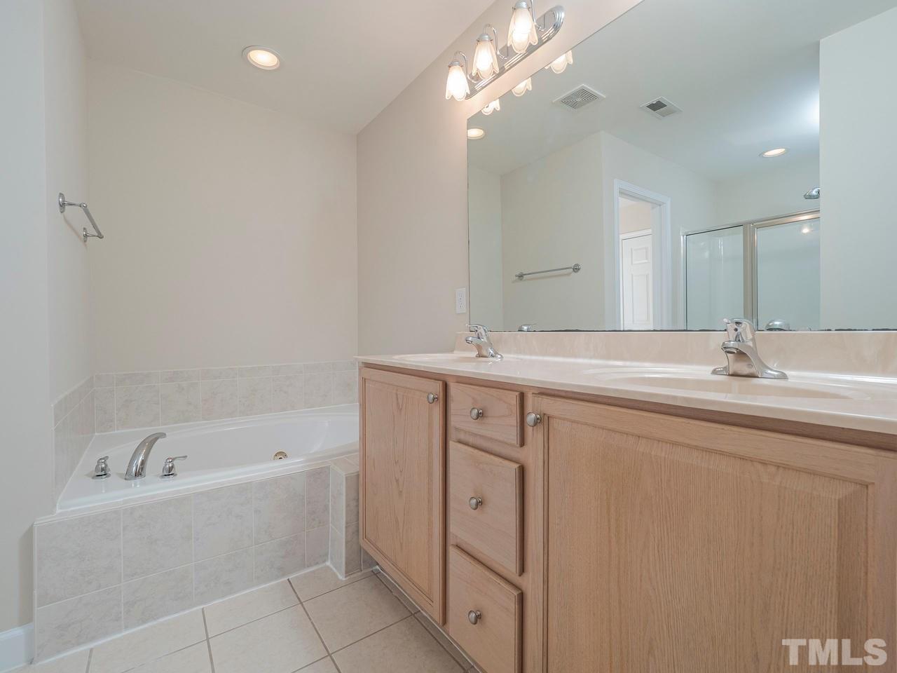 6025 Four Townes Lane Raleigh, NC 27616 - Photo 17 of 24 a bathroom with a tub sink and mirror