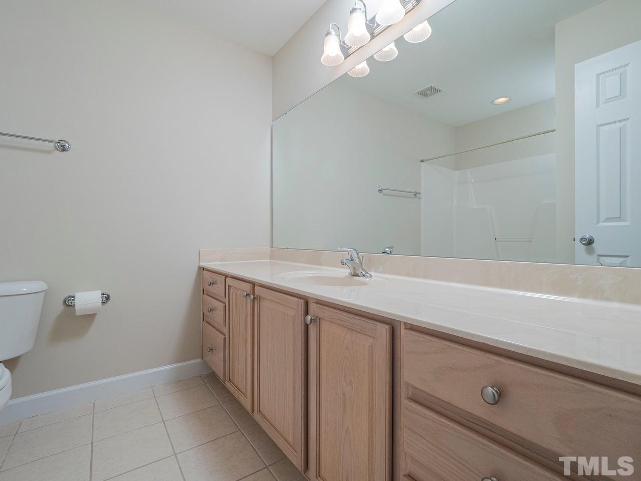 6025 Four Townes Lane Raleigh, NC 27616 - Photo 20 of 24 a bathroom with a sink a toilet and a mirror
