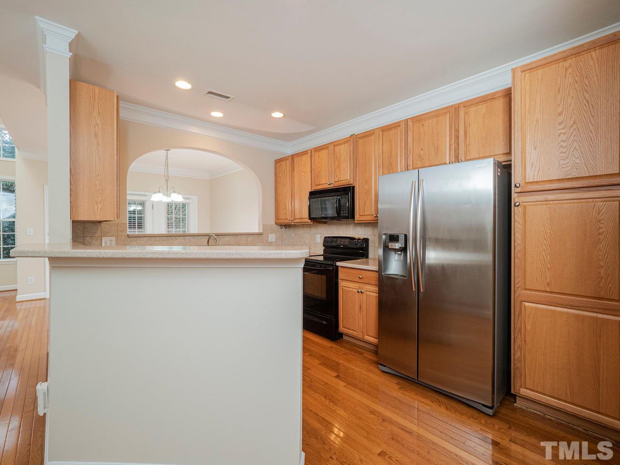 6025 Four Townes Lane Raleigh, NC 27616 - Photo 6 of 24 a modern kitchen with stainless steel appliances granite countertop a refrigerator a stove a sink and a microwave