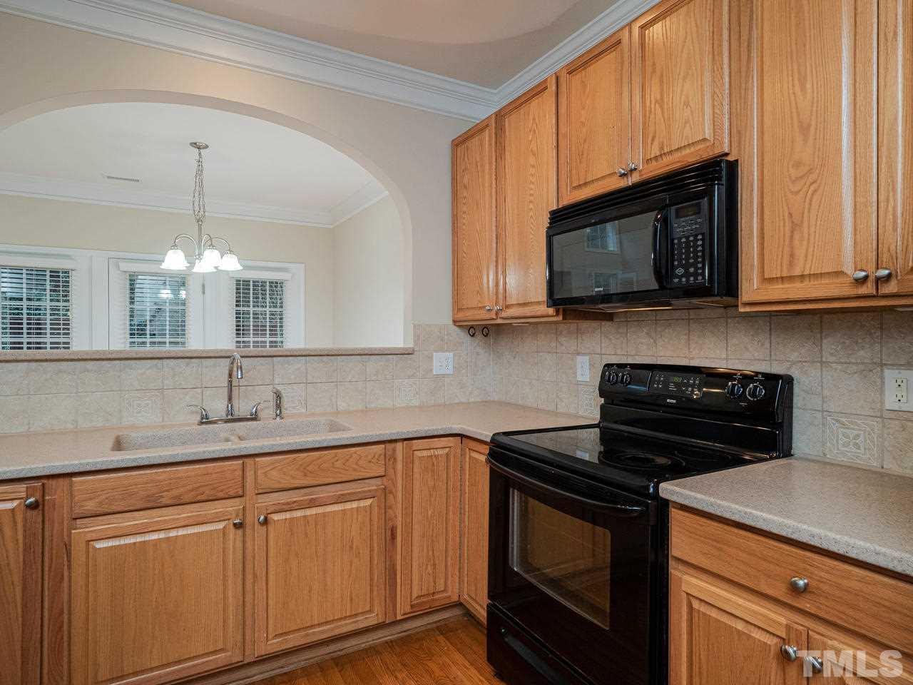6025 Four Townes Lane Raleigh, NC 27616 - Photo 8 of 24 a kitchen with stainless steel appliances granite countertop white cabinets a sink and dishwasher