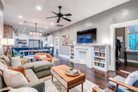 a living room with furniture a ceiling fan and a flat screen tv