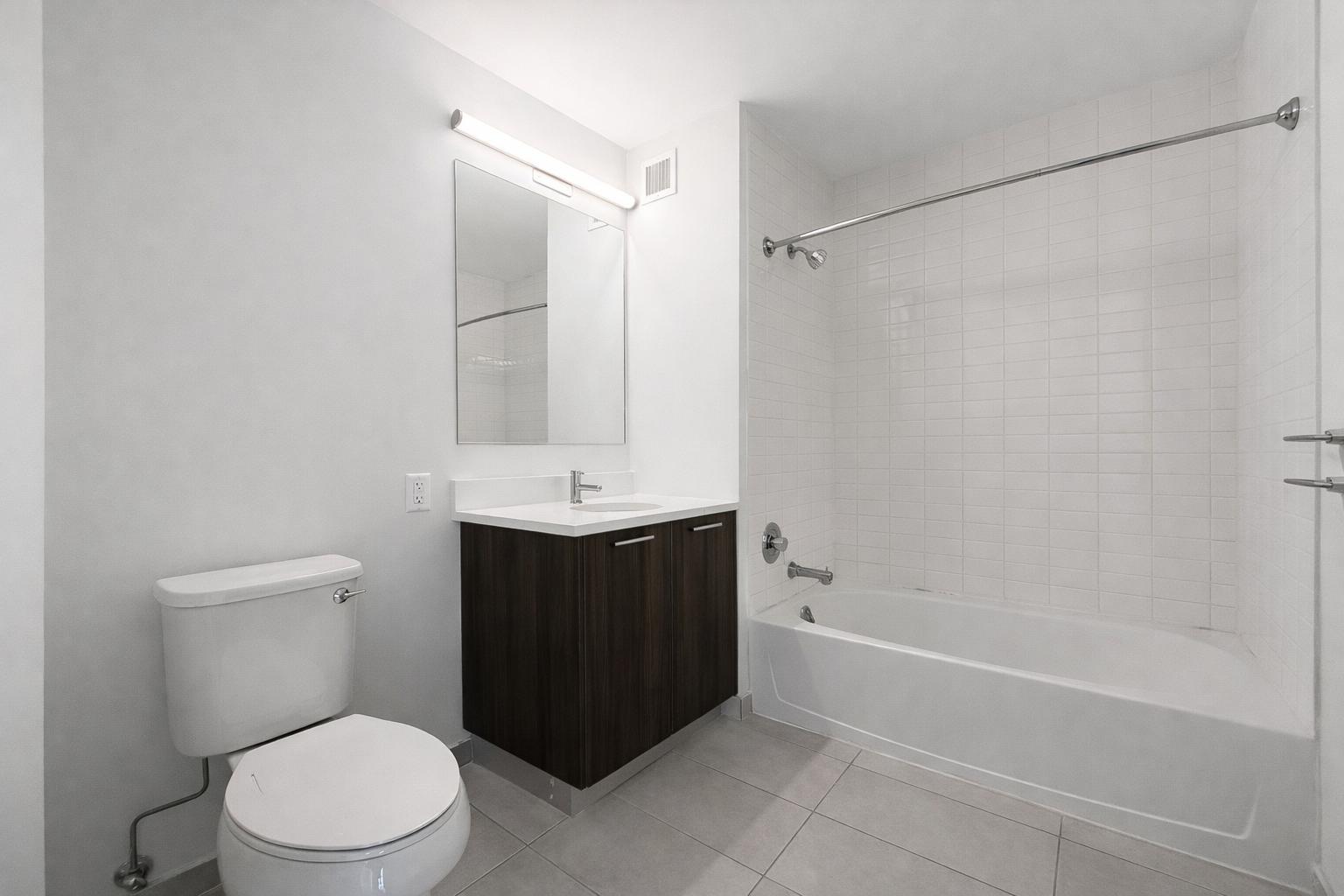 1524 Sheepshead Bay Road, Unit 18J Brooklyn, NY 11235 - Photo 7 of 25 a bathroom with a sink a toilet and shower
