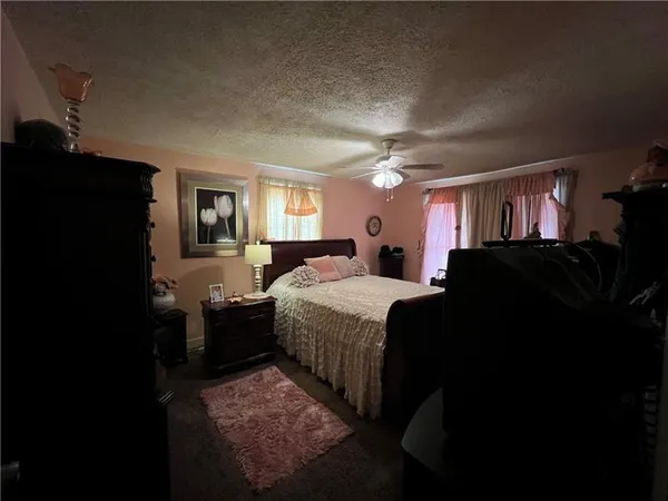 a bedroom with a bed and dresser with mirror
