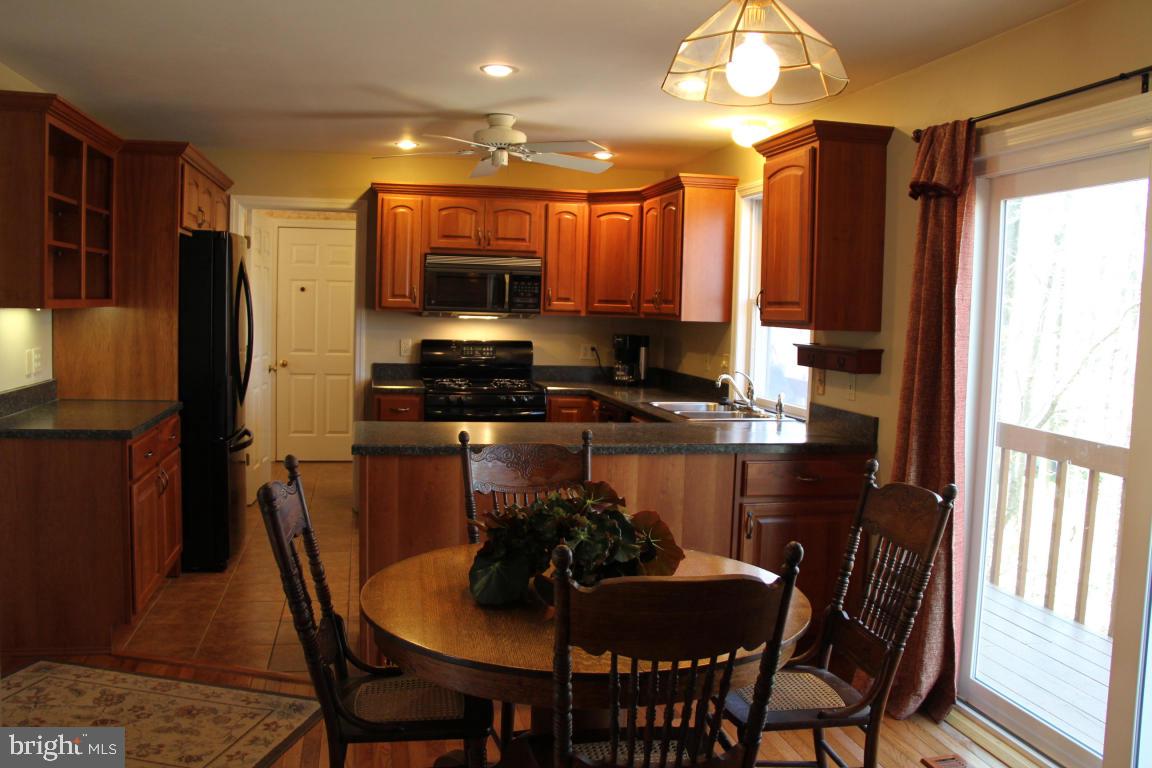 3 Warren Circle Lititz, PA 17543 - Photo 4 of 27 a kitchen with stainless steel appliances a dining table chairs sink refrigerator and microwave