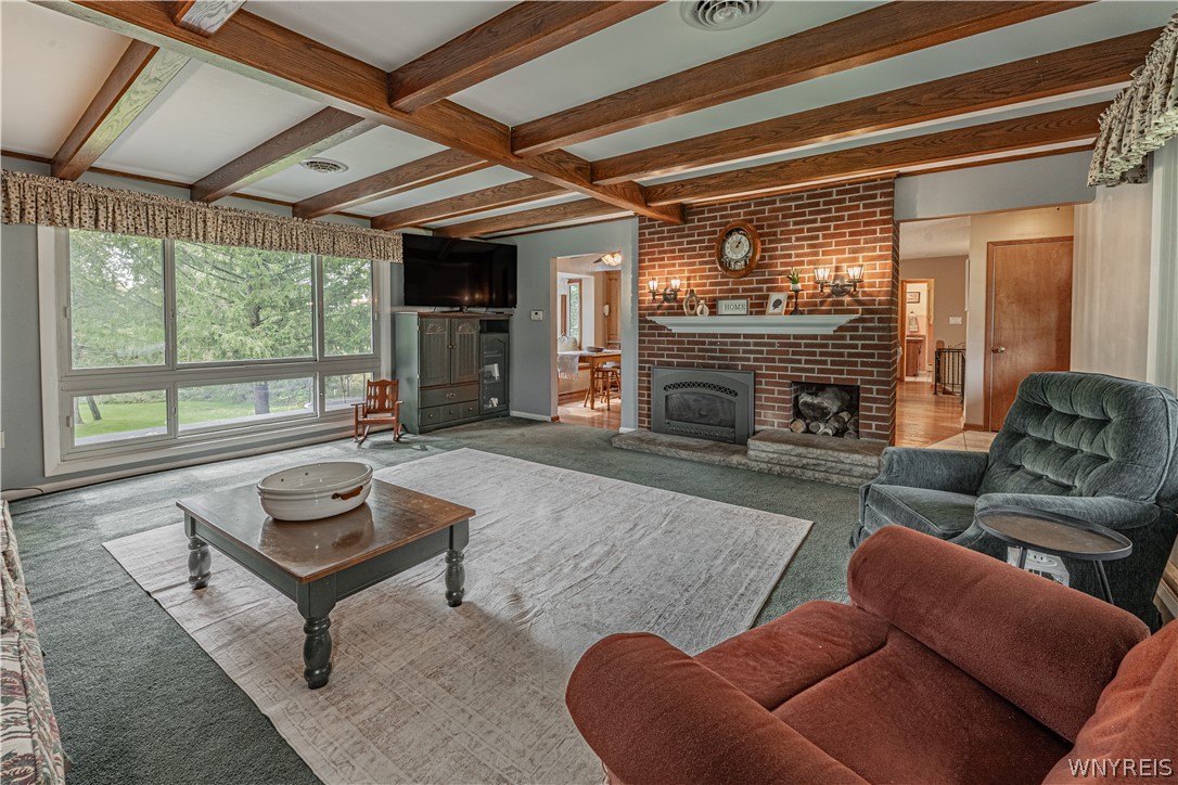 6775 Bear Ridge Road Pendleton, NY 14094 - Photo 15 of 48 Rich wood ceiling beams and a brick fireplace define this comfortable living room.