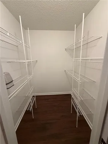 a view of walk in closet with empty racks