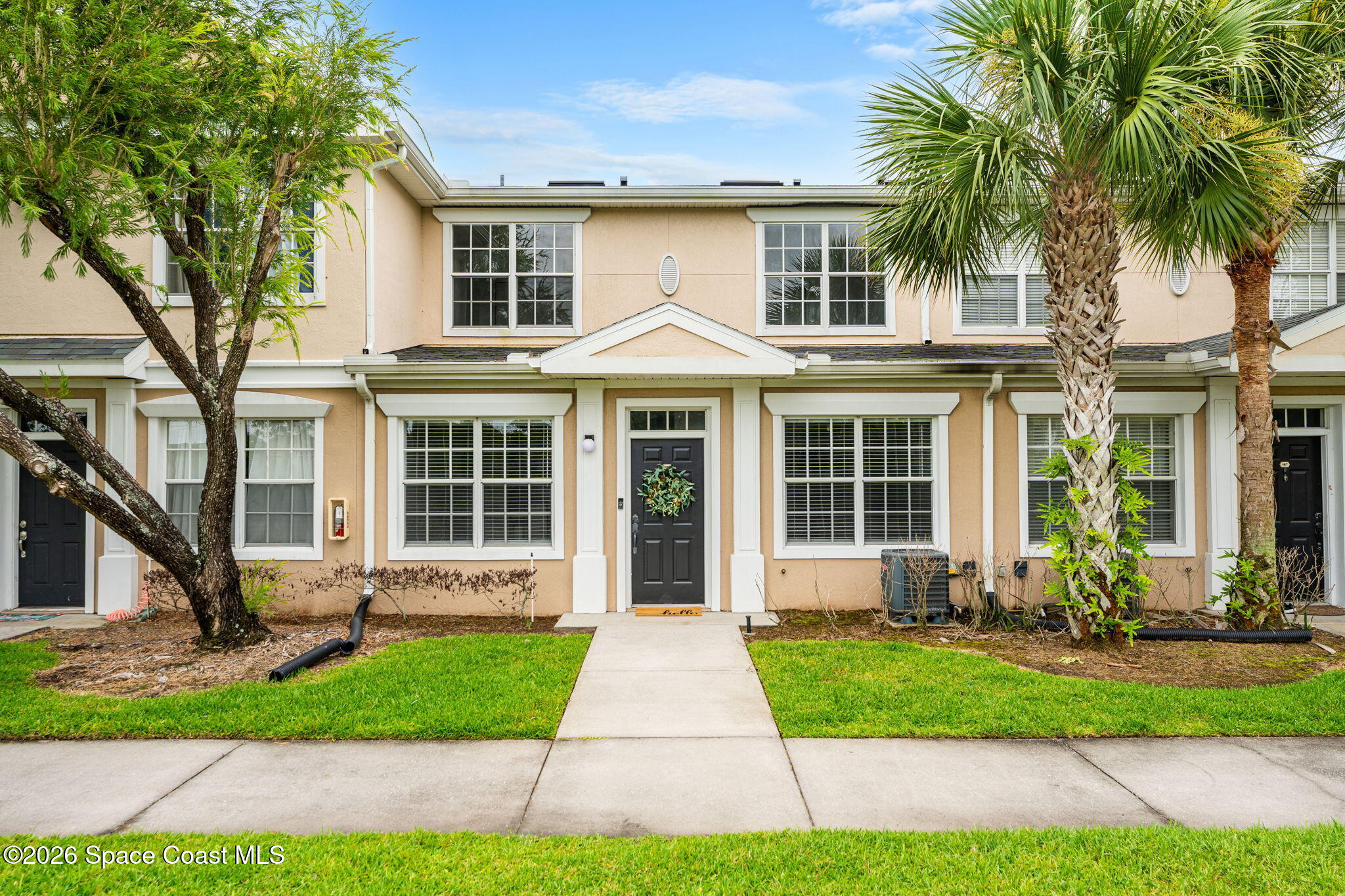 110 Turpial Way, Unit 106 Melbourne, FL 32901 - Photo 46 of 50 a front view of a house with a yard and potted plants